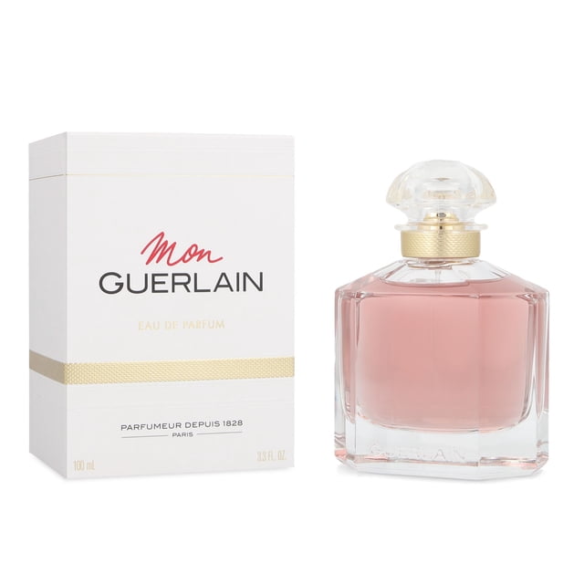 mon guerlain 100 ml edp spray nueva fragancia oriental amaderada para mujer, frasco facetado frontal de vidrio con perfume rosado y tapón transparente con collar dorado; caja blanca con logo Mon Guerlain y banda dorada a la izquierda, 100 ml.