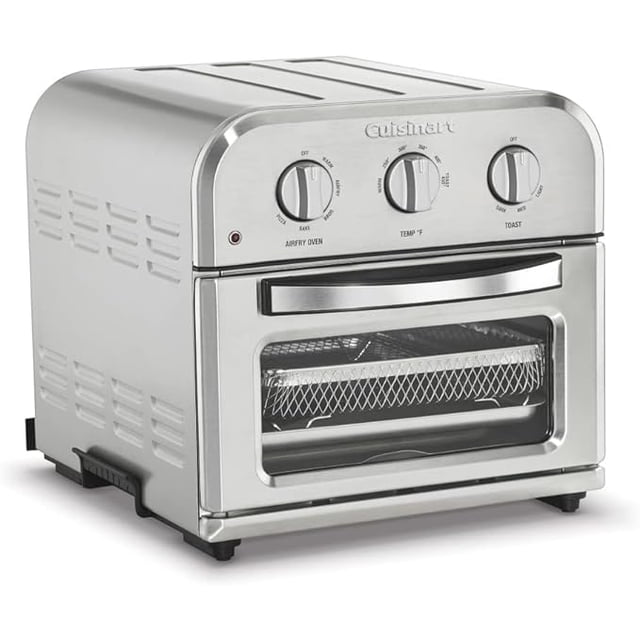 horno tostador compacto cuisinart toa-26 multicolor, vista frontal 3/4 con puerta de vidrio; carcasa de acero inoxidable, panel superior con tres perillas para función, temperatura y tostado, manija cromada, cesta AirFryer y bandeja interior visibles. Funciones: hornear y asar por convección, freír con aire, tostar, pizza y calentar; capacidad hasta 2.5 lb, adecuado para porciones pequeñas.