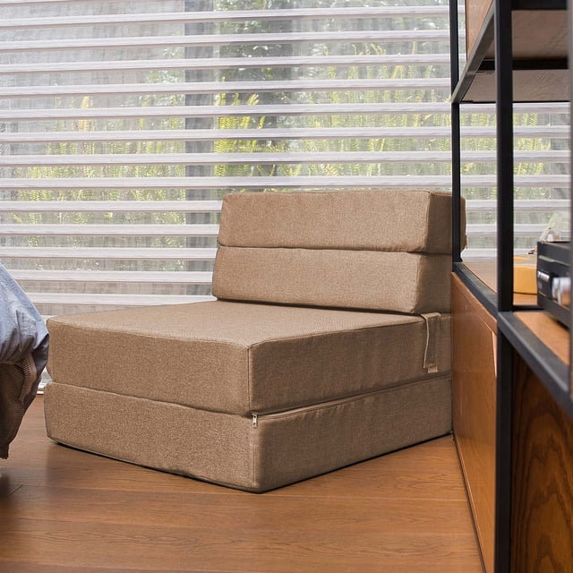 sofá cama plegable - individual - marrón claro- memory foam home sofa cama cozy sofá cama individual plegable color marrón claro con tapiz liso, asiento y respaldo de espuma memory foam según especificación, funda removible con cierre y costuras visibles, vista 3/4 en habitación compacta junto a estantería y persiana; versátil como sofá o cama y también apto para acolchar temporalmente una zona de lectura o invitados ocasionales.