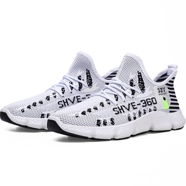tenis hombre, zapatos hombre deportivos, zapatos de malla transpirable para hombre, zapatillas de deporte casuales de moda para entrenamiento caminar correr gimnasio Blanco Shendy Vendy — Par de tenis blancos de malla transpirable con cordones frontales, suela texturizada blanca y puntera negra, estampado negro en laterales y tirador en talón con detalle verde. Vista 3/4 frontal que muestra perfil bajo y diseño liviano; adecuados para caminar, correr y gimnasio; también suelen usarse como calzado casual para viajar.