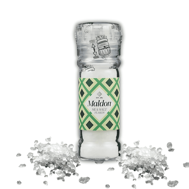 molinillo maldon sal blanca 55g sal gourmet inglesa Molinillo transparente con etiqueta verde y crema, con 55 g de escamas de sal blanca, vista frontal centrada con montones de escamas a ambos lados; utensilio de cocina que suele usarse también para terminar platos al servir.