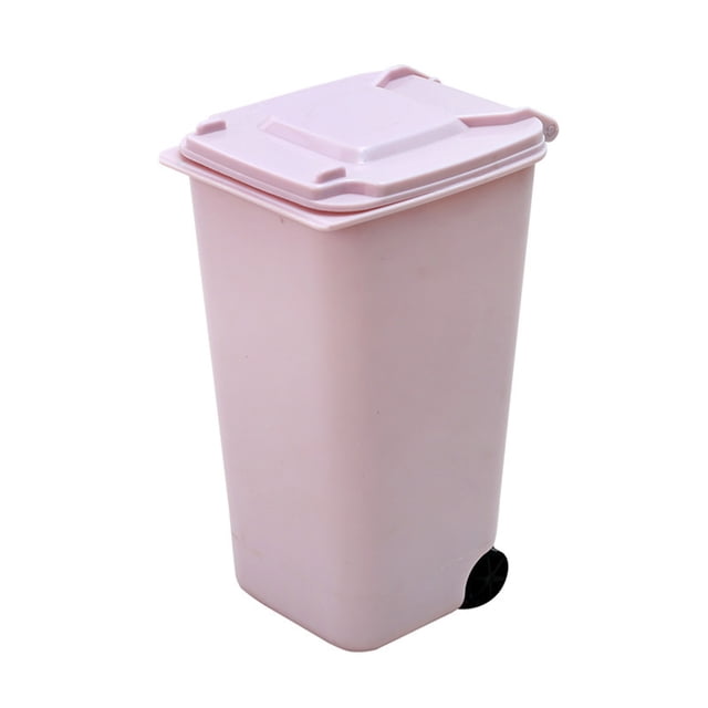 bote de basura billuyoard de escritorio de plástico rosa claro con ruedas. Vista frontal en 3/4 de un cubo rectangular compacto con tapa a presión cuadrada y superficie lisa; rueda negra visible en la base, tamaño aprox. 15×10×8 cm, para escritorio, cocina o dormitorio; a menudo se usa también para almacenar residuos pequeños o desechos de oficina.