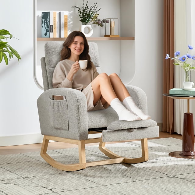 yeshouse mecedora mecedora para guardería con reposapiés ajustable, respaldo alto, suave acolchado, dos bolsillos laterales, patas de madera maciza, cómodo sillón para sala de estar y dormitorio Vista 3/4 frontal de una mecedora glider tapizada en gris claro tipo peluche con respaldo alto ergonómico y reposapiés ajustado; cojines de espuma de alta densidad en asiento y respaldo, dos bolsillos laterales para controles o libros, base oscilante y patas de madera clara, ambientada en sala con alfombra y mesa auxiliar. Suele usarse para lactancia o momentos de descanso.
