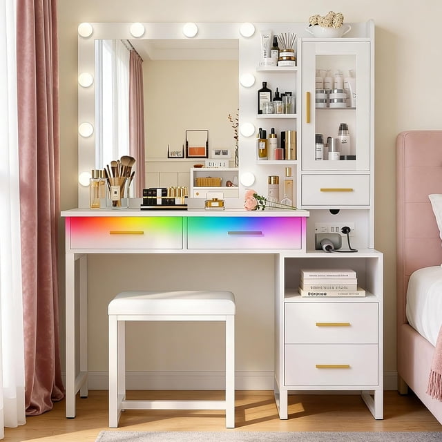 tocador, vanity con luces led rgb ajustable y estación de carga, tocador con taburete, 5 cajones, 1 puertas, escritorio de maquillaje y silla para dormitorio, 100 * 40 * 149cm blanco Wumubs. Vista frontal del tocador blanco con espejo enmarcado por 10 bombillas LED y tira RGB perimetral ajustable; superficie con organizadores y espejo con brillo y tono regulable (frío, cálido, natural). Sección lateral derecha con puerta acrílica transparente y estante interior ajustable, cinco cajones y estación de carga integrada con 2 enchufes AC y 2 puertos USB visibles. Taburete tapizado centrado frente al escritorio, tiradores dorados y acabado blanco mate en un dormitorio con cortina rosada. También adecuado para organizar accesorios de cuidado personal o almacenar dispositivos de belleza durante viajes.