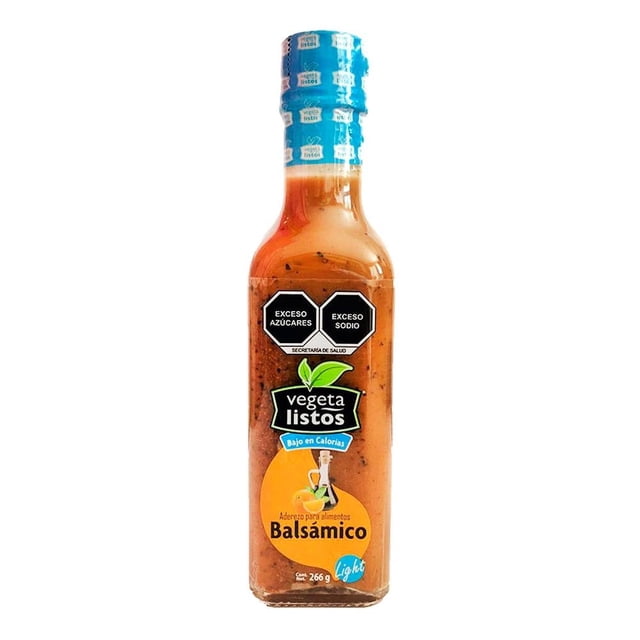 aderezo balsámico vegetalistos bajo en calorías 250 ml botella frontal centrada de vidrio translúcido con líquido ámbar y partículas de hierbas, etiqueta verde y naranja con logo VEGETALISTOS y leyenda 'Bajo en Calorías', tapa azul con envoltura protectora; también suele usarse para marinar vegetales antes de asar.