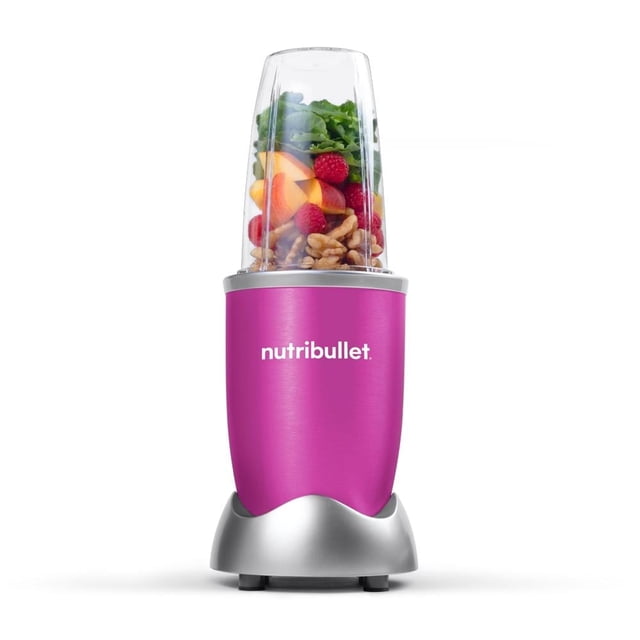procesador de alimentos nutribullet 600w 1 velocidad rosa — vista frontal centrada del procesador portátil rosa con base plateada y logo nutribullet, vaso transparente de plástico con frutas y nueces visibles, aspas de acero inoxidable expuestas y diseño compacto de 5 piezas sobre fondo blanco; a menudo usado para preparar batidos para llevar.