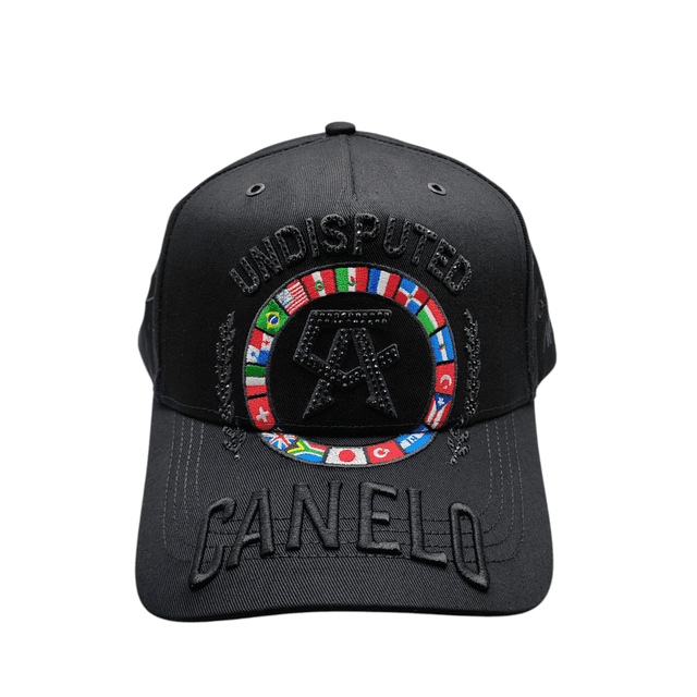 canero-1 Gorra Dandy Hats Canelo Undisputed edición exclusiva, gorra negra vista frontal con visera curva; bordado “UNDISPUTED” en hilo negro sobre la copa, anillo de banderas multicolor alrededor del monograma central, bordado “CANELO” en la visera y costuras visibles; estilo urbano para fans y uso casual.