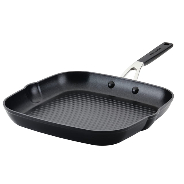 sartén y plancha kitchenaid, anodizado duro, antiadherente, 28 cm — Placa cuadrada negra ónix en vista 3/4 con interior acanalado y crestas elevadas, boquillas de vertido integradas, mango remachado con agarre de silicona y borde que muestra base de aluminio gruesa; adecuada para asar carnes, pollo o pescado y uso diario.