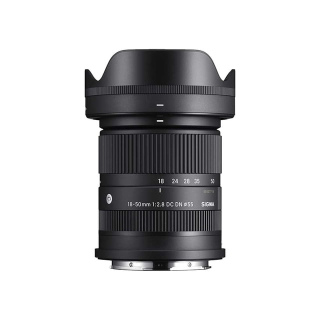 lente sigma 18-50mm f2.8 dc dn (c) -x sigma f2.8 dc dn (c) -x lente zoom estándar compacto 18-50 mm f/2.8 para montura Fujifilm X (APS-C), vista frontal centrada sobre fondo blanco; barril negro con anillos de zoom y enfoque marcados 18–50 y texto de modelo visible, parasol instalado y mención de diafragma de 7 láminas y apertura constante f/2.8; también es adecuado para fotografía de paisajes, retratos y video/vlogging ligero.