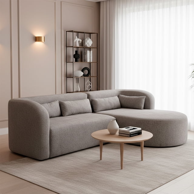sala modular katy, atlas del descanso, color gris con tapizado en lino moderno sala modular en L con chaise lounge, vista frontal; silueta curva y brazo redondeado, tapizado gris tipo lino y cojines riñonera y rectangulares a juego, relleno de espuma poliuretano de alta densidad indicado en especificaciones, patas ocultas sobre alfombra neutra, luz natural desde cortina blanca y estantería decorativa al fondo; diseño ergonómico ideal para descanso y lectura.