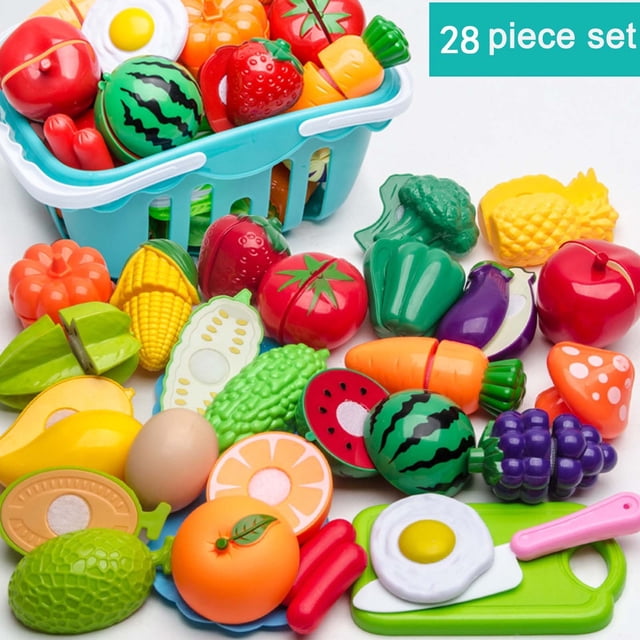 cocina interactiva para niños con carrito de la compra y cortador de verduras | sonido realista y pegatinas reutilizables | comida de juguete para niños y niñas Vista cenital de set de comida de juguete sobre fondo blanco: cesta azul con asas con frutas y verduras de plástico (sandía, fresa, tomate), piezas partidas por la mitad, huevo frito en sartén pequeña, tabla y cortador en verde y rosa, piezas en rojo, naranja, amarillo, verde y morado con texturas y ranuras visibles. Adecuado para juego de simulación y carrito de compras infantil.