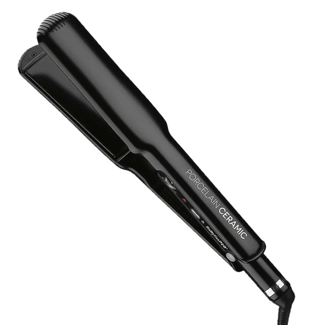 plancha de cabello babyliss pro porcelain ceramic bp9557, placas de 1" (2,5 cm) negra, vista 3/4 frontal con cuerpo ergonómico y acabado brillante, texto "PORCELAIN CERAMIC" en la carcasa, placas lisas de porcelana-cerámica, control de temperatura con indicador y cable giratorio; temperatura ajustable hasta 450°F (232°C), ideal para alisar, crear ondas y estilizar con precisión; también suele usarse para definir mechas y retoques rápidos.