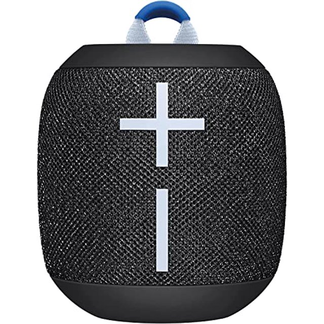 ultimate ears wonderboom 3, altavoz bluetooth inalámbrico portátil negro con sonido 360 grados; vista frontal centrada de cilindro compacto con rejilla de tela texturizada negra, botones de volumen grandes en forma de cruz blancos, base y borde superiores de goma negra y asa de tela azul-gris en la parte superior, reproducción hasta 14 horas según ficha; a menudo usado como bocina portátil para actividades al aire libre.