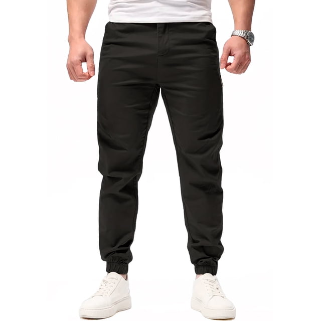 pantalon jogger para hombre shendy vendy slim fit stretch con cordon Negro, vista frontal de cuerpo entero hasta los tobillos. Jogger slim de tiro medio con pretina y cordón visible, puños elásticos en tobillos y tela lisa de tacto suave; modelo usa tenis blancos sobre fondo neutro, adecuado también para uso casual diario.