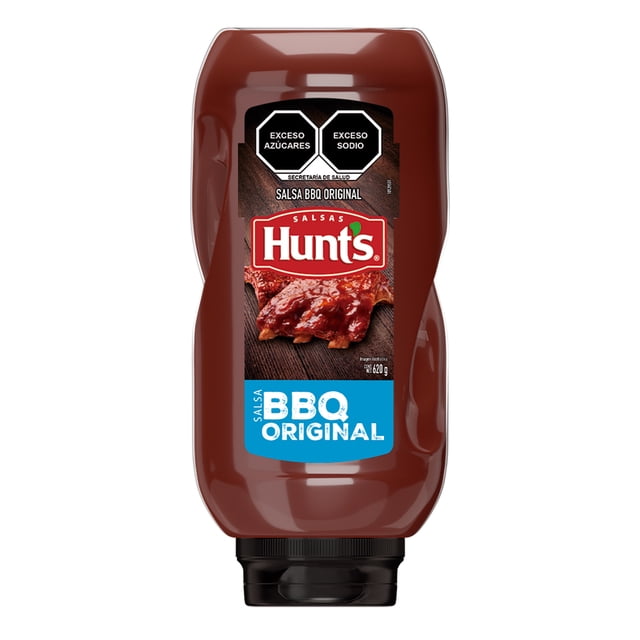 salsa bbq hunts original 620 g Botella plástica invertida 620 g, vista frontal con tapa negra; etiqueta Hunt's roja sobre foto de costillas con salsa, recuadro azul 'BBQ ORIGINAL' y sellos 'Exceso azúcares' y 'Exceso sodio'; apta como aderezo o para marinar pollo, carnes y papas.