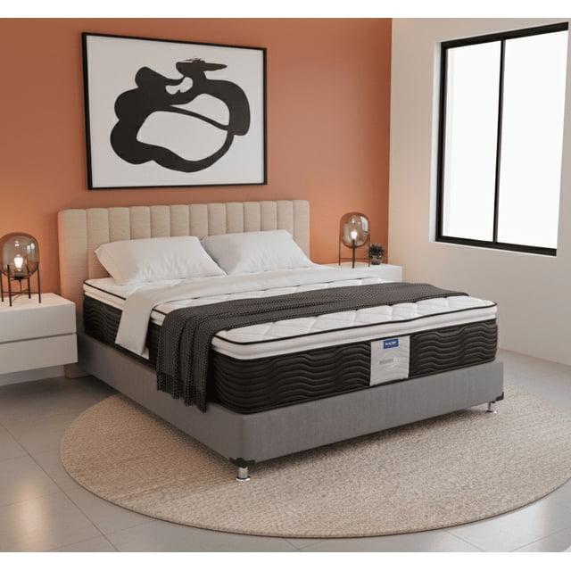 colchon king size restonic ortopedico moon care calm 3/4 frontal de colchón king size Restonic Moon Care Calm sobre base tapizada gris; laterales negros con patrón ondulado, superficie acolchada blanca con costuras y etiqueta Restonic visible en el pie, cabecero beige y ropa blanca. Diseño ergonómico con soporte ortopédico medio a semi firme; suele usarse en recámaras principales.