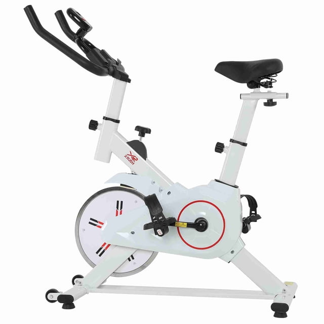 bicicleta fija de spinning x-rush spinx 8kg color blanco 3/4 lateral, manubrio en U regulable, asiento acolchado con ajuste vertical y horizontal, rueda de inercia 8 kg con resistencia ajustable, pedales con correas, porta celular y base con soportes antiderrapantes.
