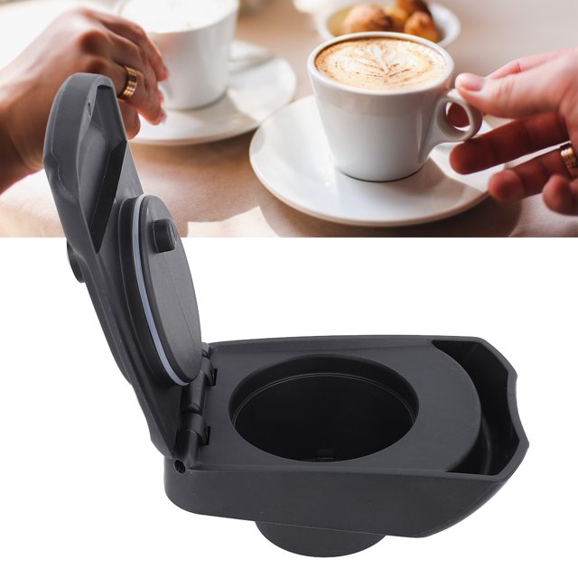 convertidor de cápsulas, adaptador de cápsula reutilizable recargable resistente al calor para café Tebru: vista frontal 3/4 del adaptador abierto, cuerpo de PP negro con tapa abatible, hueco interior circular de aprox. 99,5x67,5 mm y junta visible, base moldeada para encajar en portacápsulas; a menudo usado también para preparar porciones de café personalizadas en viajes.