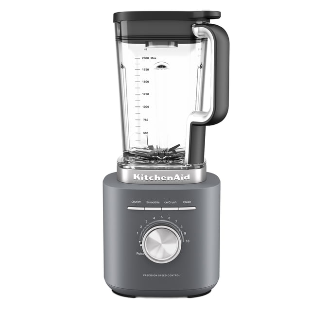 licuadora kitchenaid 10 velocidades 1700 w 2 l color gris — vista frontal centrada con base gris mate y jarra de tritán transparente de 2 L; perilla metálica numerada 1 a 10 con función pulso, tres botones preestablecidos (Smoothie, Ice Crush, Clean), cuchillas asimétricas de acero inoxidable visibles y logotipo KitchenAid en la base. Suele utilizarse también para preparar salsas y cremas caseras.