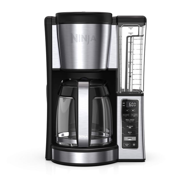 cafetera ninja programable para 12 tazas con depósito de 1.8 litros Vista frontal centrada de la cafetera Ninja en negro y acero inoxidable; jarra de vidrio de 12 tazas con mango cromado sobre placa de calentamiento ajustable; depósito de agua transparente extraíble con marcadores de nivel (60 oz/1.8 L) a la derecha; panel digital con pantalla y botones para 'small batch', 'classic' y 'rich' y función de preparación retardada hasta 24 horas. Su tamaño la hace adecuada para preparar café para reuniones pequeñas en casa.
