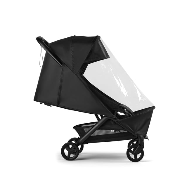 cubre lluvia impermeable para cochecito bugaboo butterfly 2 — Vista lateral frontal de cubre lluvia negro instalado sobre cochecito Bugaboo Butterfly 2; capota y laterales en material opaco con ventana frontal transparente de plástico, costuras y bordes ajustados visibles; se pliega ordenadamente para almacenamiento y suele usarse para proteger el asiento durante traslados breves.