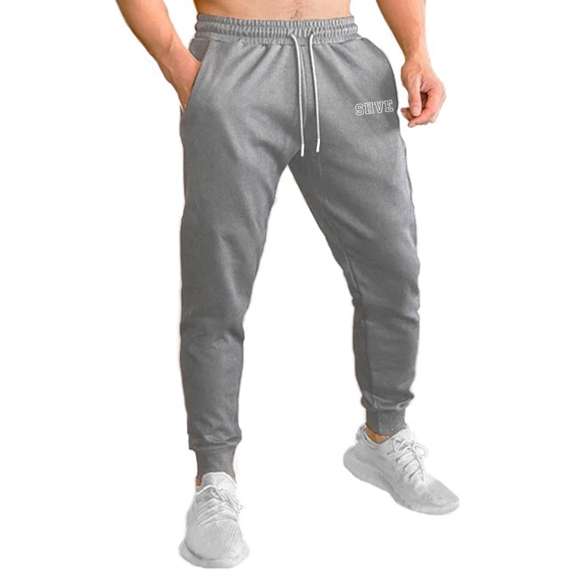 pants jogger para hombre shendy vendy deportivo slim fit elástico Gris Jaspe, vista frontal centrada de joggers slim con cintura elástica acanalada y cordón funcional con puntas plateadas, puños tipo jogger y bolsillos laterales visibles, logo Shendy Vendy en pierna; adecuado para entrenamiento, uso casual y viajes cortos.