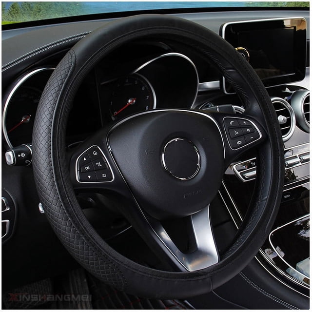 funda para volante de coche, protector de volante de coche, diámetro 38 cm (15"), piel Negra FALCO GEAR vista frontal centrada de volante con cubierta de cuero resistente; superficie lisa superior y paneles laterales con patrón cruzado y costuras visibles, anillo interior de goma antideslizante, instalada en tablero de auto. Accesorio interior que mejora agarre y transpirabilidad y es adecuada para la mayoría de volantes estándar.