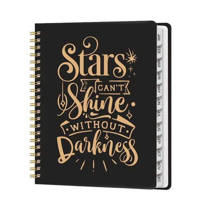 cuaderno de planificación a4 con páginas separadas, agenda de inglés 2026, cuaderno de espiral negro con tipografía dorada grande “Stars can't shine without darkness”, espiral metálica dorada a la izquierda, separadores mensuales en inglés visibles en el borde derecho, vista frontal vertical, acabado liso, pensado para planificación anual y organización.