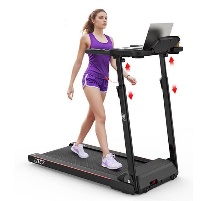 caminadora eléctrica tio keep going plegable profesional negra, vista frontal 3/4 con mujer caminando; cinta antideslizante y base compacta, estructura plegable con barandales verticales, área de trabajo amplia para laptop/tablet que permite combinar entrenamiento en casa con productividad, velocidad hasta 12 km/h y capacidad 120 kg.