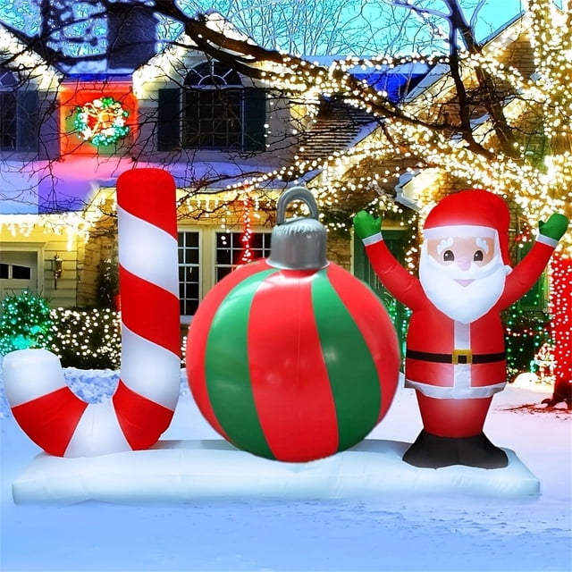 xihbxyly bola navideña inflable de 60 cm para exteriores multicolor, ideal para patio o porche. Vista frontal centrada de la bola roja y verde de 60 cm con remate plateado sobre base blanca, acompañada por Papá Noel inflable a la derecha y bastón de caramelo a la izquierda; PVC resistente con acabado vibrante y costuras visibles; fondo con casa y luces navideñas. Suele emplearse para crear escenas festivas en jardines o entradas.