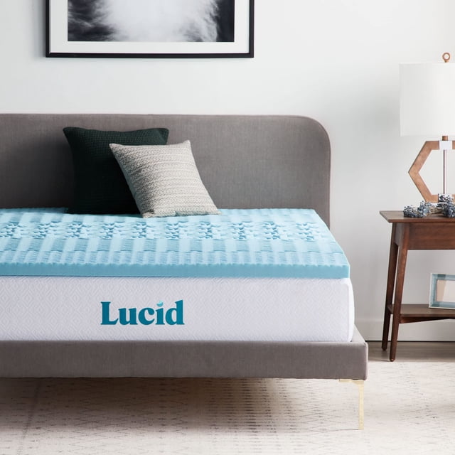 cubrecolchón lucid memory foam, 5 zonas, infusión de gel, 5 cm cubrecolchón aqua de 2 pulgadas (5 cm) con superficie ventilada y patrón acolchado por zonas, borde blanco con logo Lucid visible sobre cama matrimonial en dormitorio minimalista; también se usa como acolchado extra para añadir confort en colchones delgados.