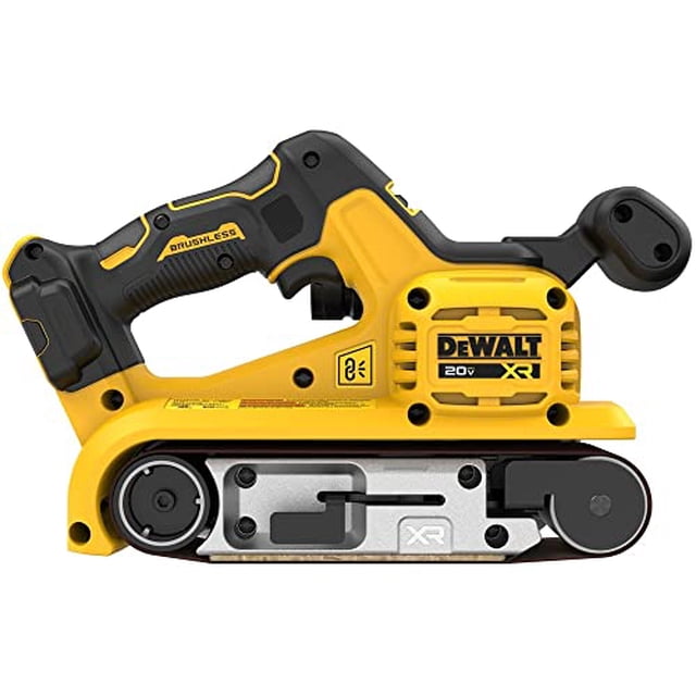 lijadora de banda dewalt 20v max* xr inalámbrica 3x21 pulgadas Vista lateral de la lijadora amarilla y negra DEWALT, formato 3 x 21 pulg., motor sin escobillas, empuñadura sobremoldeada con gatillo de velocidad variable y dial, plato metálico con correa abrasiva instalada, rodillos visibles y puerto de extracción de polvo compatible con adaptadores de 35 mm; adecuada para desbaste rápido de piezas de madera en talleres móviles.