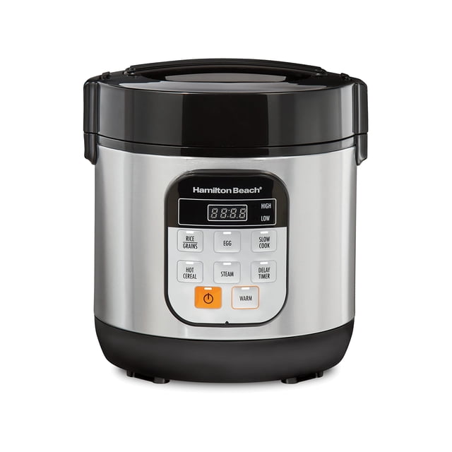 olla multifuncional hamilton beach 37524 digital 1.4 litros negro. Vista frontal centrada de la arrocera y vaporera de acero inoxidable con base negra y tapa con asa; panel digital con pantalla LED y botones visibles para arroz, huevo, cocción lenta, vapor y temporizador de retardo; botón naranja de encendido y función warm; capacidad para 6 tazas cocidas (3 crudas); incluye bandeja para huevos y pala arrocera, diseñada para 1–2 personas y cocinas pequeñas.