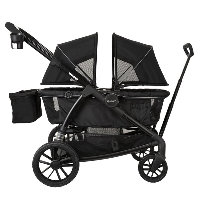 safety 1st carriola wagon for 2 negro Carriola doble para 2 niños en vista lateral 3/4. Estructura negra con dos asientos y capotas ajustables, doble arnés de 3 puntos con protectores de hombros, charola interior para juguetes y canasta superior para objetos pequeños. Mango recubierto para empujar, manija frontal para jalar, canasta inferior XL de malla y ruedas delanteras de 4” y traseras de 6” con amortiguador trasero. Suele usarse también para transportar pañaleras y juguetes en salidas familiares.