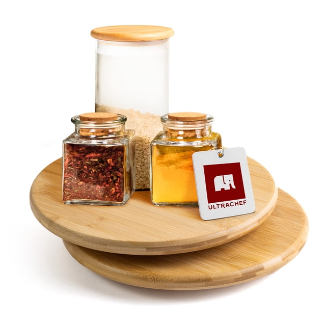 2 piezas bandeja giratoria lazy susan de bambú Ultrachef, pack de 2 platos giratorios de 25 cm, vista frontal centrada de dos bases de bambú claro apiladas con vetas naturales y borde biselado; superficie lisa con frascos de especias y etiqueta con logo Ultrachef sobre la bandeja superior. Funciona como organizador de cocina, especiero o centro de mesa y suele usarse también como base giratoria para pasteles o para organizar cosméticos en el tocador.