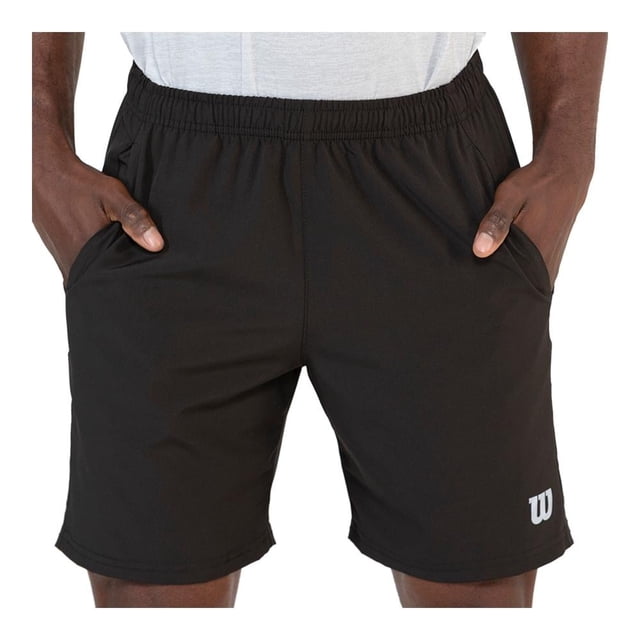 bermuda wilson talla eg deportivo negro. Vista frontal centrada de bermuda deportiva negra con cintura elástica y jareta, bolsillos laterales con manos dentro y logo blanco "W" en pierna derecha; corte por encima de la rodilla y tejido de poliéster ligero, ideal para entrenamiento y uso prolongado; también suele utilizarse como short casual para sesiones de ejercicio ligero.