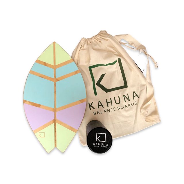 tabla de balance kahuna balance boards mini surf (mediana) para adulto cursi hecha a mano en México 60x33 cm 18 mm, vista cenital frontal de tabla en forma de hoja de madera de pino sólido pintada en bloques azul claro, rosa y verde claro con franjas doradas; incluye rodillo de espuma negro de alta densidad y bolsa de viaje beige con logo Kahuna; adecuada para uso recreativo y ejercicios de equilibrio, también suele usarse para prácticas de yoga.