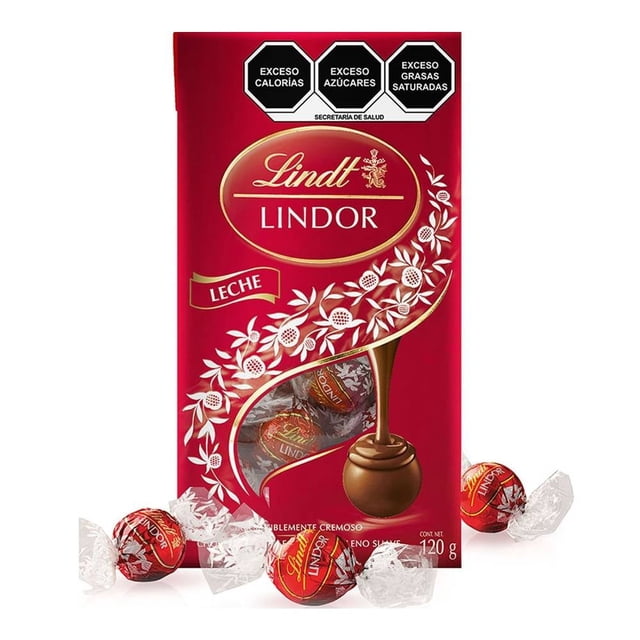 trufas de chocolate lindt lindor con leche 120 g paquete vertical rojo con logo Lindt Lindor y ventana circular que muestra bombones envueltos en primer plano, vista frontal, decorado con ramas blancas y etiqueta 'leche'. Presentación para regalar o compartir; también apto para mesas de postres en eventos familiares.