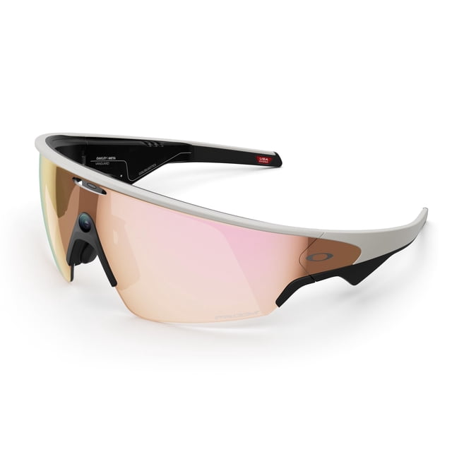 gafas inteligentes meta vanguard con ia, audio y lente prizm Vista 3/4 frontal de las gafas Meta Vanguard con armazón blanco y lente Prizm Rose Gold de una pieza; cámara ultra gran angular integrada en la montura central, puente nasal negro ajustable y patillas negras con detalle rojo y logotipo. Se aprecian las salidas de audio de oído abierto y acabado mate; fondo blanco minimalista. Su diseño es ideal para grabar video 3K Ultra HD, recibir métricas de entrenamiento vía Meta AI al emparejarse con dispositivos Garmin y escuchar audio por Bluetooth durante actividades al aire libre.