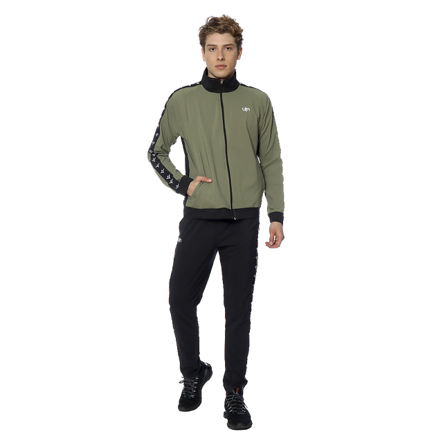 conjunto pants entrenamiento deportivo uin caballero liso conjunto para entrenamiento color olivo-negro. Vista frontal de modelo de pie con chamarra olivo con cierre completo y cintas laterales negras estampadas, logo UIN en pecho, pantalón negro ajustado con puños y zapatillas negras; talla XGDE, apto para gimnasio y uso deportivo.