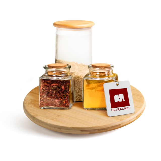 bandeja giratoria lazy susan de bambú ultrachef, charola organizadora de cocina para especias, botanero, base giratoria para mesa, almacenamiento, 25cm, 1 pieza Vista frontal centrada de la bandeja giratoria Ultrachef de 25 cm con superficie circular de bambú y borde bajo. Tres frascos de vidrio con tapas de madera y una etiqueta con logotipo están sobre la base; se aprecian vetas de bambú y acabado liso; fondo blanco aislado. Ideal como especiero giratorio, centro de mesa o charola botanera para mesa y alacena; también suele usarse para organizar condimentos o cosméticos en espacios pequeños.