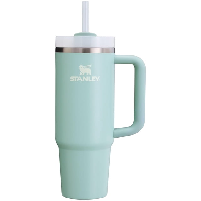 vaso stanley quencher h2.0 con mango y pajita, 900 ml, seafoam Vaso de acero inoxidable aislante color seafoam, vista frontal centrada con asa a la derecha; acabado mate, anillo de acero inoxidable pulido bajo la tapa blanca con pajita reutilizable visible, logo Stanley en el frente y base estrecha compatible con portavasos. A menudo usado también como termo de bebida fría para viajes cortos.