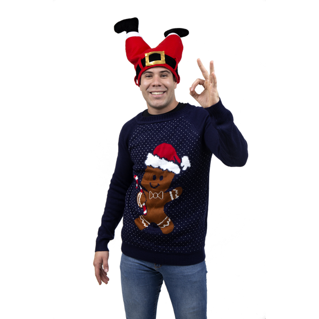 sueter ugly rev galletita navideña adulto color negro tejido hombre de frente con suéter negro tejido que muestra una galleta de jengibre con gorro navideño rojo y borde blanco, cuello redondo, mangas largas y patrón de puntos pequeños, estilo ropa navideña; fondo de estudio.