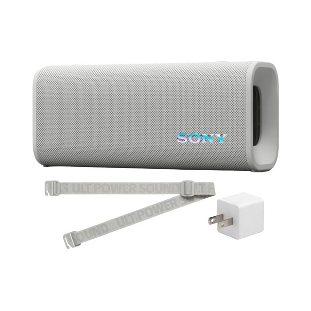 bocina portátil inalámbrica sony ult field 3 resistente al agua Bocina Sony ULT FIELD 3 blanco off white, vista frontal centrada con rejilla texturizada y logo Sony, forma rectangular con aberturas laterales para bajos, correa para hombro plegable extendida y adaptador de corriente blanco a la derecha sobre fondo neutro; ideal para uso en exteriores.