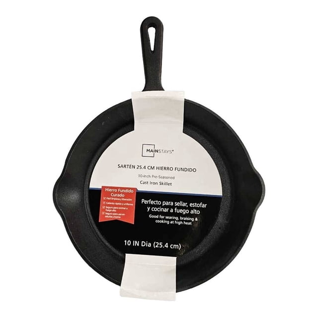 sartén mainstays hierro fundido mango gris vista frontal centrada de 25.4 cm (10 in) con asa larga perforada en gris y superficie negra de hierro fundido, etiqueta de cartón que indica uso en estufa, horno y parrilla; ideal para sellar y cocinar a fuego alto y a menudo usada para dorar pequeñas piezas de carne o verduras.