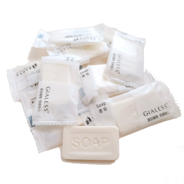 set 10 jabones hoteleros 7g | jabón mini para baño y manos | espuma abundante | cuidado e hidratación de la piel paquete de diez jaboncitos blancos individuales (7 g cada uno) con envoltura blanca impresa y barras rectangulares con 'SOAP' en relieve; vista frontal apilada sobre fondo neutro, apto como amenidad de lavabo en hoteles y alojamientos, también adecuado para kit de higiene de viaje.
