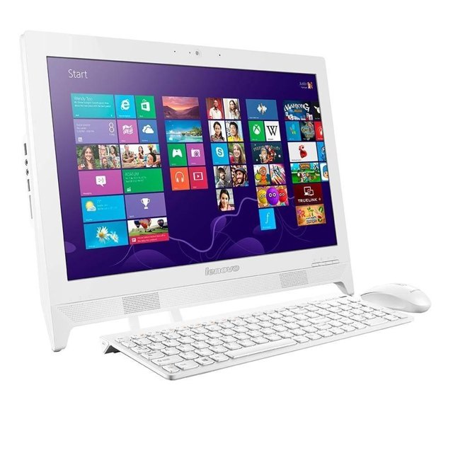 computadora de escritorio lenovo c260 intel celeron 2gb ram 500gb dd All-in-One blanca, vista frontal 3/4 con pantalla de 19.5" mostrando Windows, teclado y mouse blancos delante; rejilla de altavoces bajo la pantalla, puertos laterales visibles, 500 GB de almacenamiento y puerto USB 3.0 para carga rápida. A menudo usada en oficinas y escuelas por su diseño compacto.