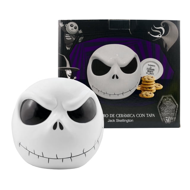 galletero decorativo de cerámica, jack skellington en 3d con tapa hermética, 30 aniversario “el extraño mundo de jack” con caja de regalo. Vista frontal centrada de un galletero blanco de cerámica en forma de cabeza de Jack Skellington en 3D; ojos hundidos negros, nariz triangular y boca con líneas tipo costura; tapa superior visible. Colocado frente a su caja de regalo impresa; mide 19 cm de alto x 14 cm de diámetro; apto como recipiente para galletas, dulces o adorno coleccionable para fiestas de Halloween.