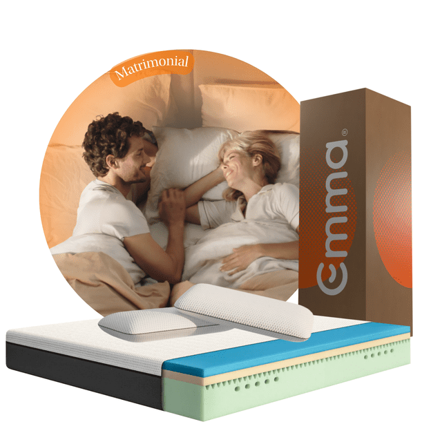 combo colchón emma original matrimonial 135x190cm memory foam y 2 almohadas memory adapt — Colchón Emma Original 135x190 cm en vista 3/4 con funda blanca texturizada, capa viscoelástica (25 cm según especificación), espuma fría HRX verde en la base y borde negro; dos almohadas Memory Adapt blancas sobre la superficie y caja Emma vertical a la derecha; fondo circular con pareja recostada; también es habitual usar el combo para ofrecer una cama extra en cuarto de visitas.