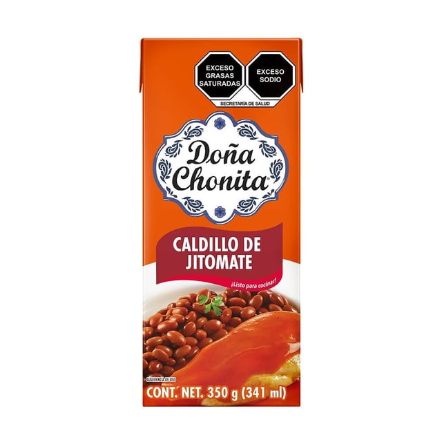 caldillo de jitomate la costeña doña chonita 350 g envase frontal naranja y blanco con logotipo Doña Chonita, texto 'Caldillo de Jitomate', ilustración de salsa roja sobre chile relleno y frijoles, sellos de advertencia 'Exceso grasas saturadas' y 'Exceso sodio', contenido neto 350 g (341 ml).